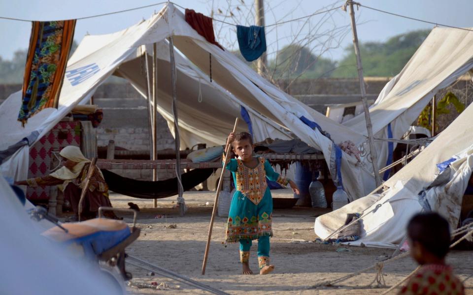 A young girl plays outside her tent at a relief camp, in Jaffarabad, a district in the southwestern Baluchistan province, Pakistan - Zahid Hussain/AP