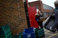 Dionne Tracey carries a crate of food items to be delivered to local residents from the Docklands Settlements Community Centre in Stratford, as the spread of the coronavirus disease (COVID-19) continues, in east London