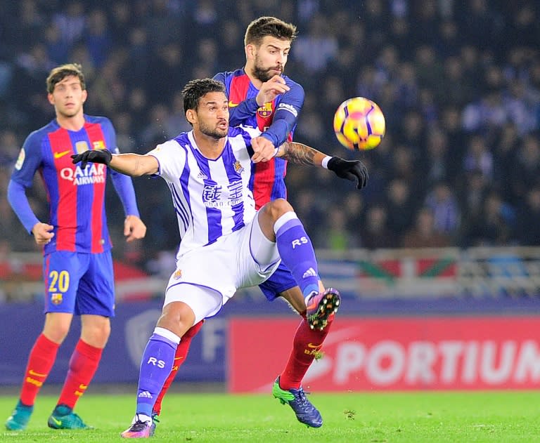 Real Sociedad's Brazilian forward Willian Jose (L) vies with Barcelona's defender Gerard Pique (R) during the Spanish league football match Real Sociedad vs FC Barcelona at the Anoeta stadium in San Sebastian, on November 27, 2016