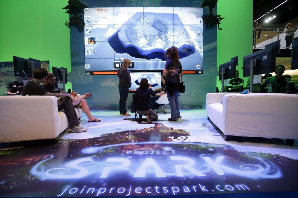 Show attendee watch a presentation on the video game "Project Spark" at the Microsoft booth during the Electronic Entertainment Expo in Los Angeles, Wednesday, June 12, 2013. (AP Photo/Jae C. Hong)