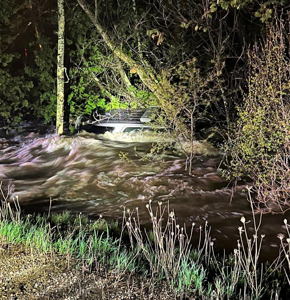 Only the top of Sgt. Chad Angus' patrol vehicle can be seen after a flash flood swept the car off a culvert, where the car fellow after a section of County A in the town of Maple Valley collapsed on May 12.