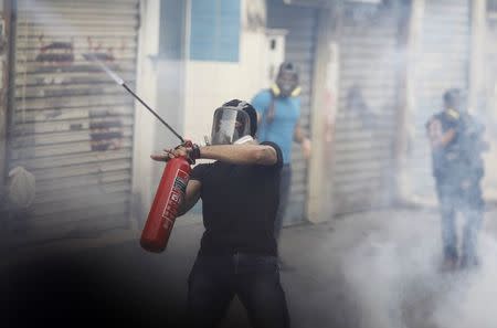 A protester fires an iron rod with a homemade weapon at riot police clashes in the village of Bilad Al Qadeem, south of Manama, January 5, 2015. REUTERS/ Hamad I Mohammed