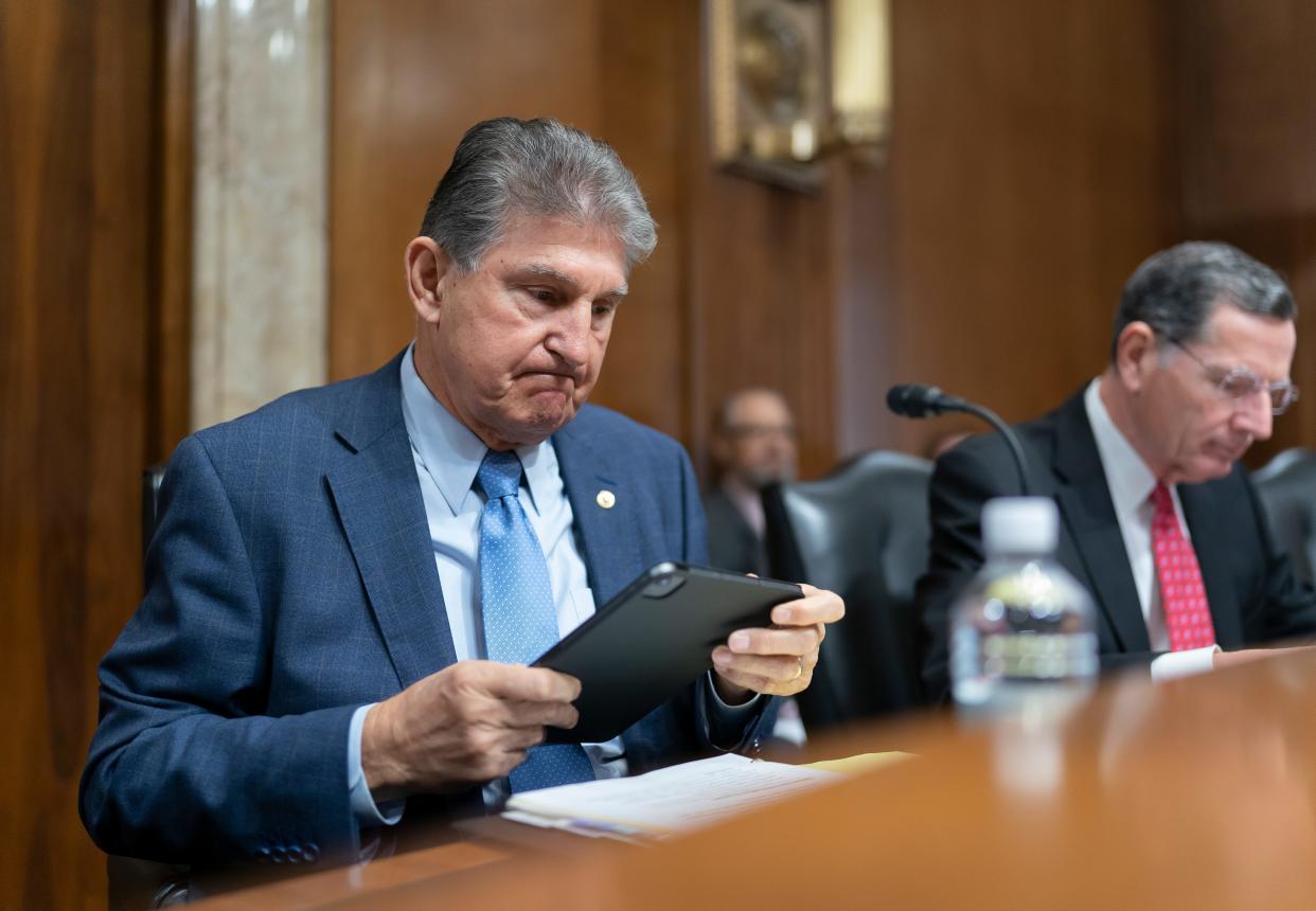 An image of Sen. Joe Manchin grimacing at an iPad