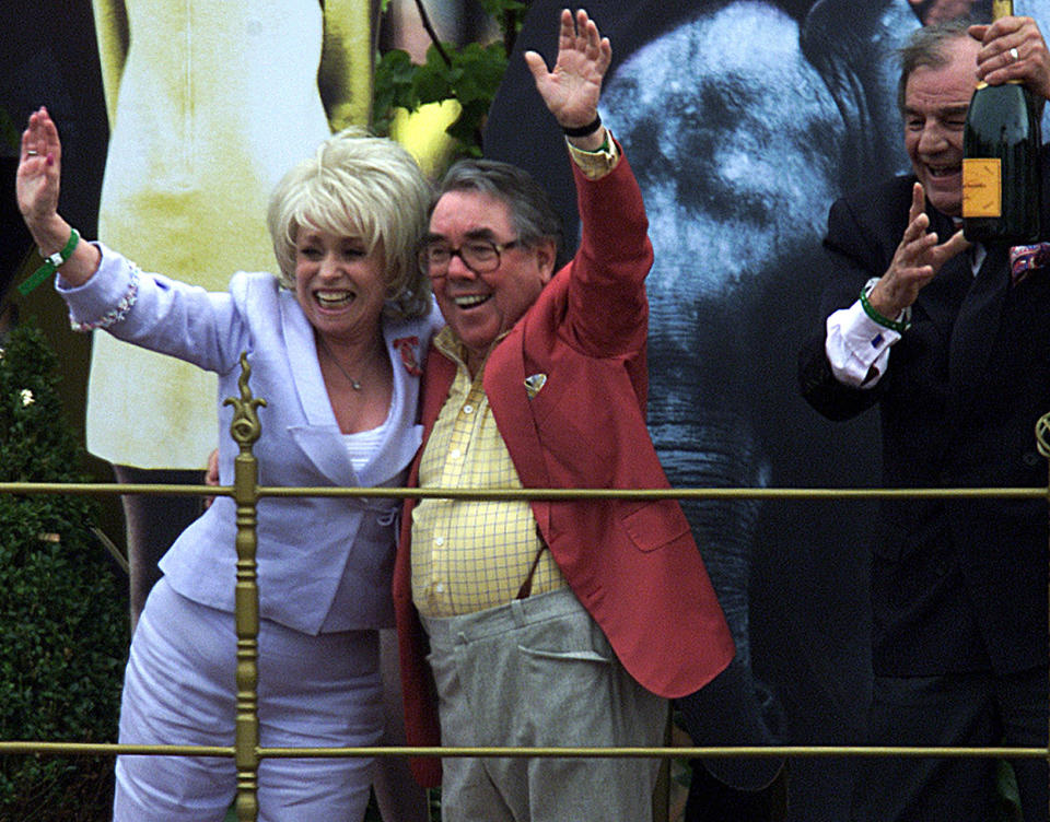 East Enders star Barbara Windsor (L) joins comedian Ronnie Corbett in saluting the Queen from a parade float during Golden Jubilee celebrations June 4, 2002. REUTERS/Chris Helgren CLH/