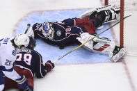 Columbus Blue Jackets goaltender Joonas Korpisalo (70) covers the puck as Tampa Bay Lightning center Brayden Point (21) and Blue Jackets center Boone Jenner (38) look for a rebound during the third period of Game 3 of an NHL hockey first-round playoff series, Saturday, Aug. 15, 2020, in Toronto. (Nathan Denette/The Canadian Press via AP)