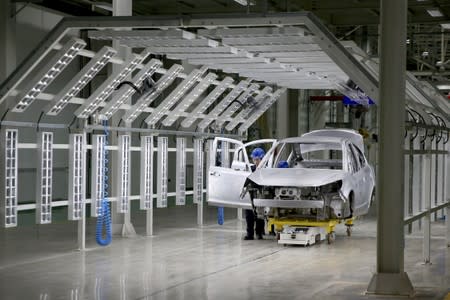 Employee works on assembling an electric vehicle (EV) at a factory of Suda Electric Vehicle Technology Co, in Sanmenxia, Henan