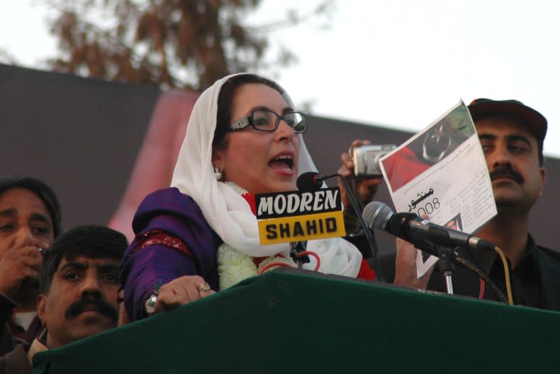 Former Pakistani Prime Minister Benazir Bhutto speaks with the watchful eye of security during an election rally in Rawalpindi on December 27, 2007. On October 18, Bhutto returned home after eight years in exile. A suicide bomber killed more than 140 people in her convoy. UPI File Photo