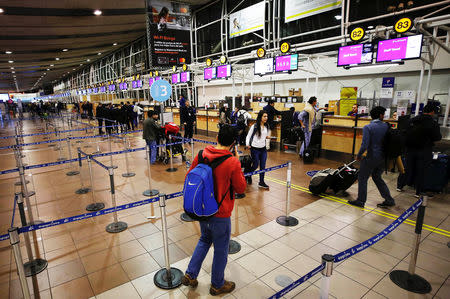 Passengers wait for check-in for their flights at the departures area of Latam airlines inside the international airport in Santiago, Chile August 16, 2018. REUTERS/Rodrigo Garrido