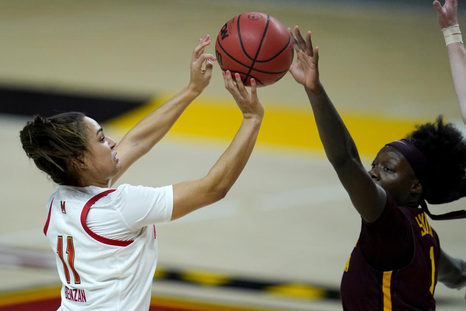 Maryland guard Katie Benzan, left, shoots against Minnesota guard Alexia Smith during the second half of an NCAA college basketball game, Saturday, Feb. 20, 2021, in College Park, Md. (AP Photo/Julio Cortez)