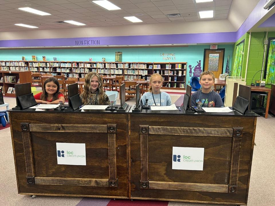 From left: Karleigh, Stella, Madelyn and Jason — fifth grade students at Challenger Elementary — work for LOC Credit Union.