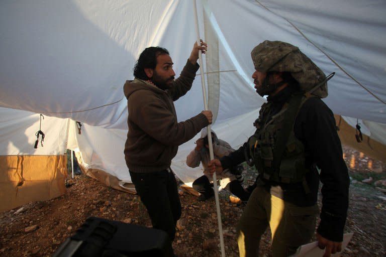 A Palestinian activist is stopped by an Israeli soldier as he protests against Jewish settlements on the outskirts of the West Bank city of Hebron, on February 9, 2013