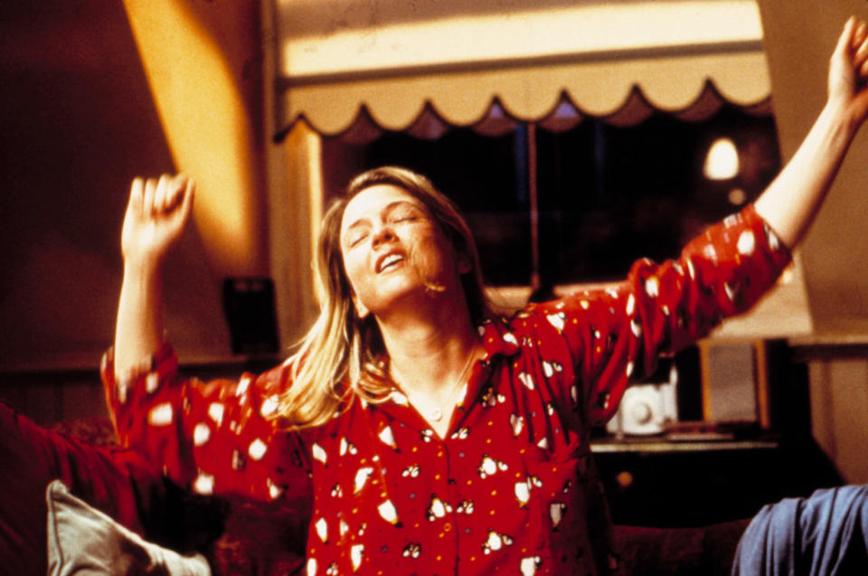 Renee Zellweger dancing with her arms in the air wearing pajamas in a scene from "Bridget Jones's Diary"