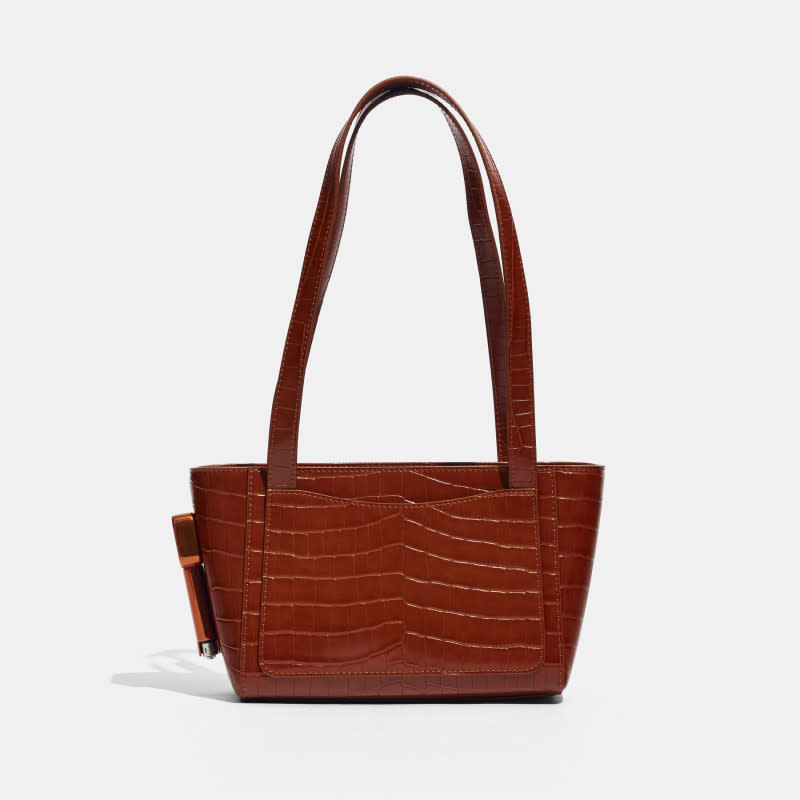 Edie Parker Burn Tote, $295, <a href="https://shareasale.com/r.cfm?b=1761626&u=2464465&m=109867&urllink=edie%2Dparker%2Ecom%2Fproducts%2Fburn%2Dmini%2Dtote%2Dfaux%2Dembossed%2Dcroc%2Dchestnut&afftrack=" rel="nofollow noopener" target="_blank" data-ylk="slk:available here;elm:context_link;itc:0;sec:content-canvas" class="link ">available here</a><p>Photo: Courtesy of Edie Parker</p>