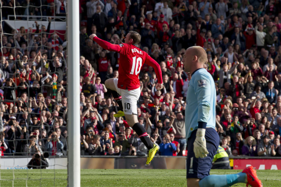 Manchester United's Wayne Rooney, centre, celebrates after scoring a penalty past Norwich City's goalkeeper John Ruddy, right, during their English Premier League soccer match at Old Trafford Stadium, Manchester, England, Saturday April 26, 2014. (AP Photo/Jon Super)