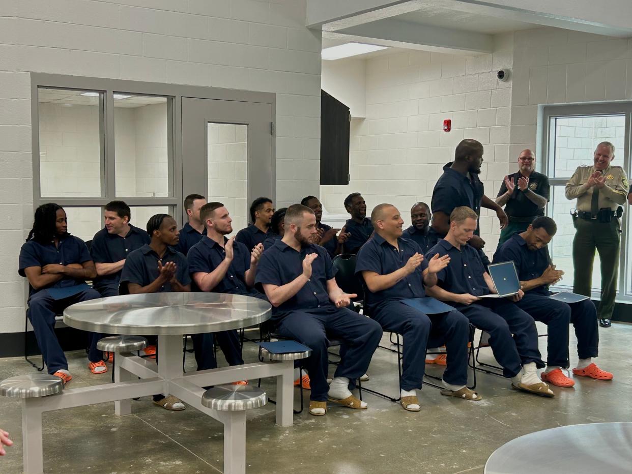 Inmates and officers clap for fellow classmate Larry Horton as he receives his certificate in manufacturing skills at the Madison Co. Jail graduation in Jackson, Tenn., on June 15, 2023.