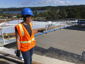 In this July 22, 2019, photo, Crystal Sanderson with Portland-based Yost Grube Hall Architecture, shows reporters an emergency access ramp that is being built alongside Oregon State University's Marine Studies Building, which is under construction in Newport, Ore. The roof will serve as a vertical evacuation zone for almost 1,000 fleeing a tsunami that an offshore quake would generate, and the ramp will be open around the clock. (AP Photo/Andrew Selsky)