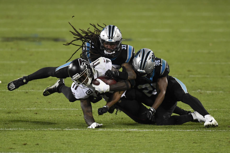 Atlanta Falcons wide receiver Julio Jones I is tackled by Carolina Panthers free safety Tre Boston and cornerback Troy Pride during the second half of an NFL football game Thursday, Oct. 29, 2020, in Charlotte, N.C. (AP Photo/Mike McCarn)