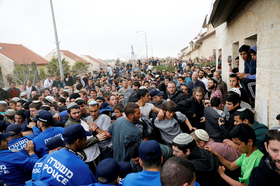 Pro-settlement activists scuffle with Israeli policemen during an operation by Israeli forces to evict residents from several homes in the Israeli settlement of Ofra, in the occupied West Bank