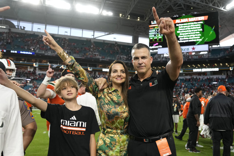 Miami head coach Mario Cristobal, right, celebrates with his family after winning an NCAA college football game against Virginia, Saturday, Oct. 28, 2023, in Miami Gardens, Fla. (AP Photo/Lynne Sladky)