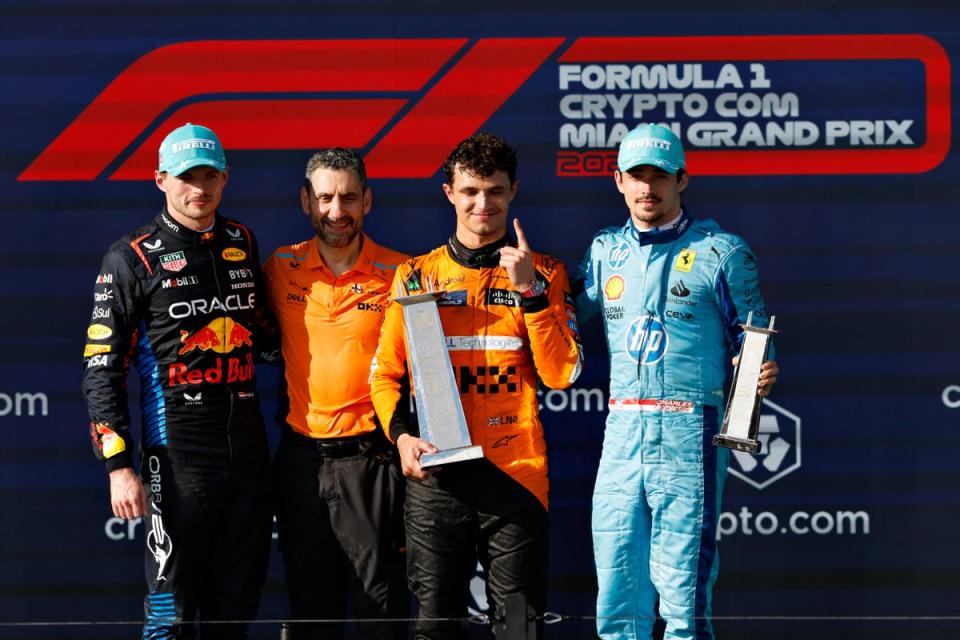 Norris smiles on top of the podium alongside McLaren team principal Andrea Stella (centre-left), Max Verstappen (left) and Charles Leclerc (right) (Getty Images)