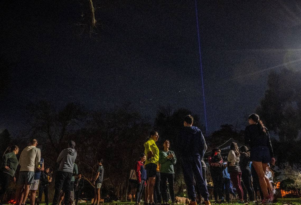 The Sacramento Kings beam lights the sky as participants of the running and walking group Corremos Sacramento gather in January after a stroll around McKinley Park in East Sacramento.