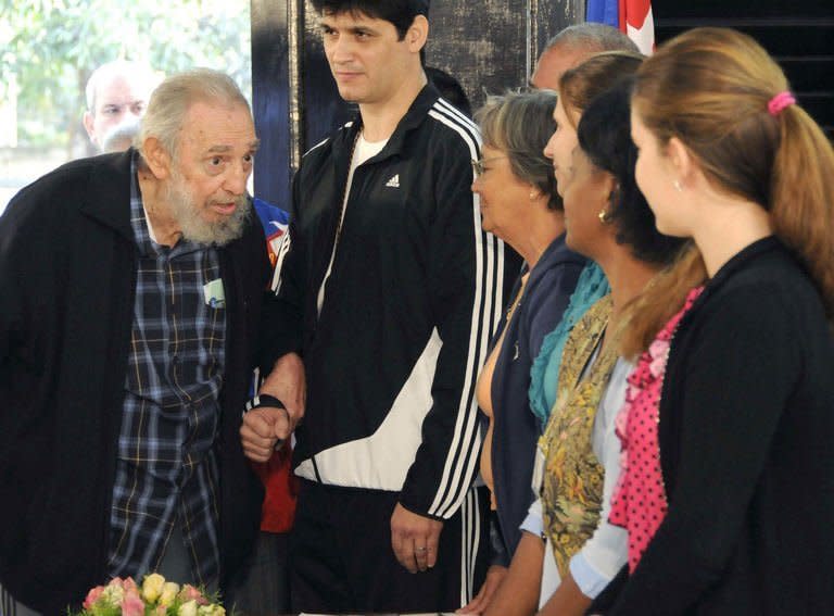 Fidel Castro (L) arrives to vote at a polling station in Havana in this photo from AIN, taken February 3, 2013. The ailing revolutionary leader expressed confidence in the revolution despite a decades-long US trade embargo