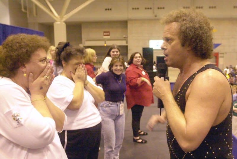 Fitness guru Richard Simmons gets Kathy Billings of Covington, Tenn., to laugh while she is on stage at the Family Expo at the America's Center in 2000. File Photo by Bill Greenblatt/UPI