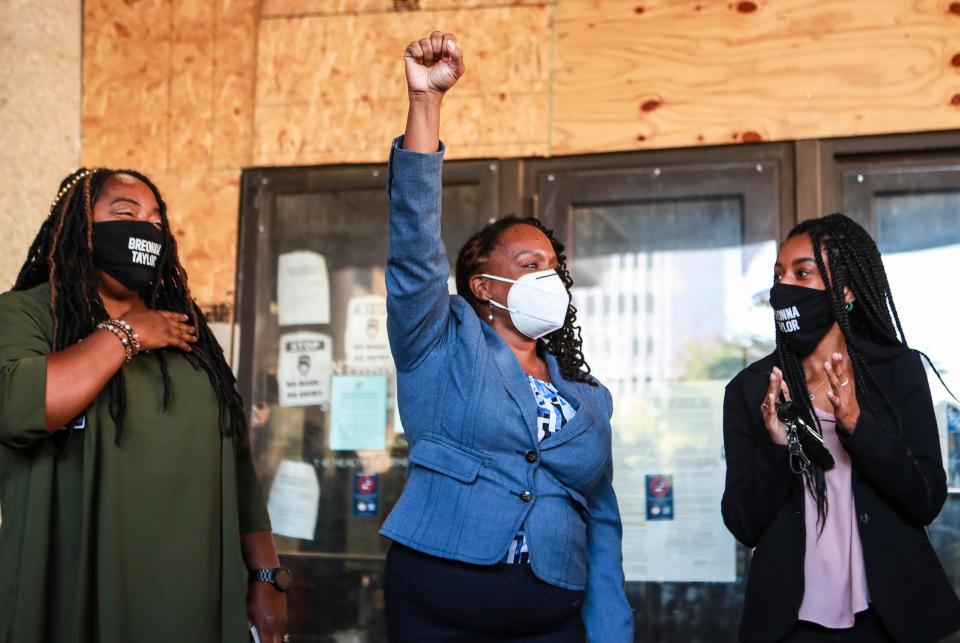 Then-state Rep. Attica Scott raised her fist as she left the Louisville Hall of Justice after an arraignment in October 2020 over an arrest at a protest, alongside Shameka Parrish-Wright (left) and Ashanti Scott. Rioting charges had been dropped in court that morning.