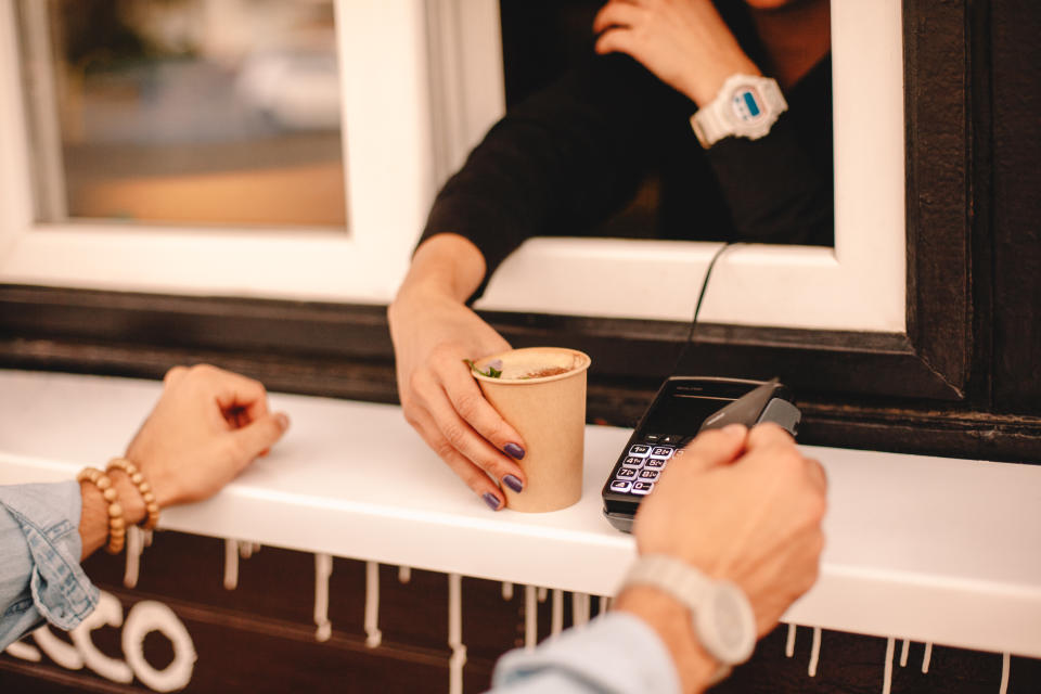 Customer making payment with credit card buying coffee on city street