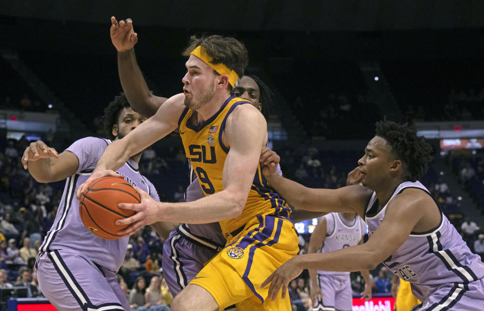 LSU forward Will Baker (9) drives to the basket past Kansas State center Will McNair Jr. (13), Kansas State forward Arthur Kaluma (24) and Kansas State guard Tylor Perry (2) during an NCAA college basketball game, Saturday, Dec. 9, 2023, at the LSU PMAC in Baton Rouge, La. (Hilary Scheinuk/The Advocate via AP)