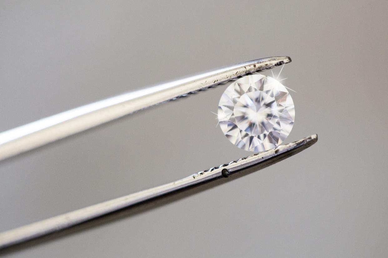 diamond being inspected with tweezers