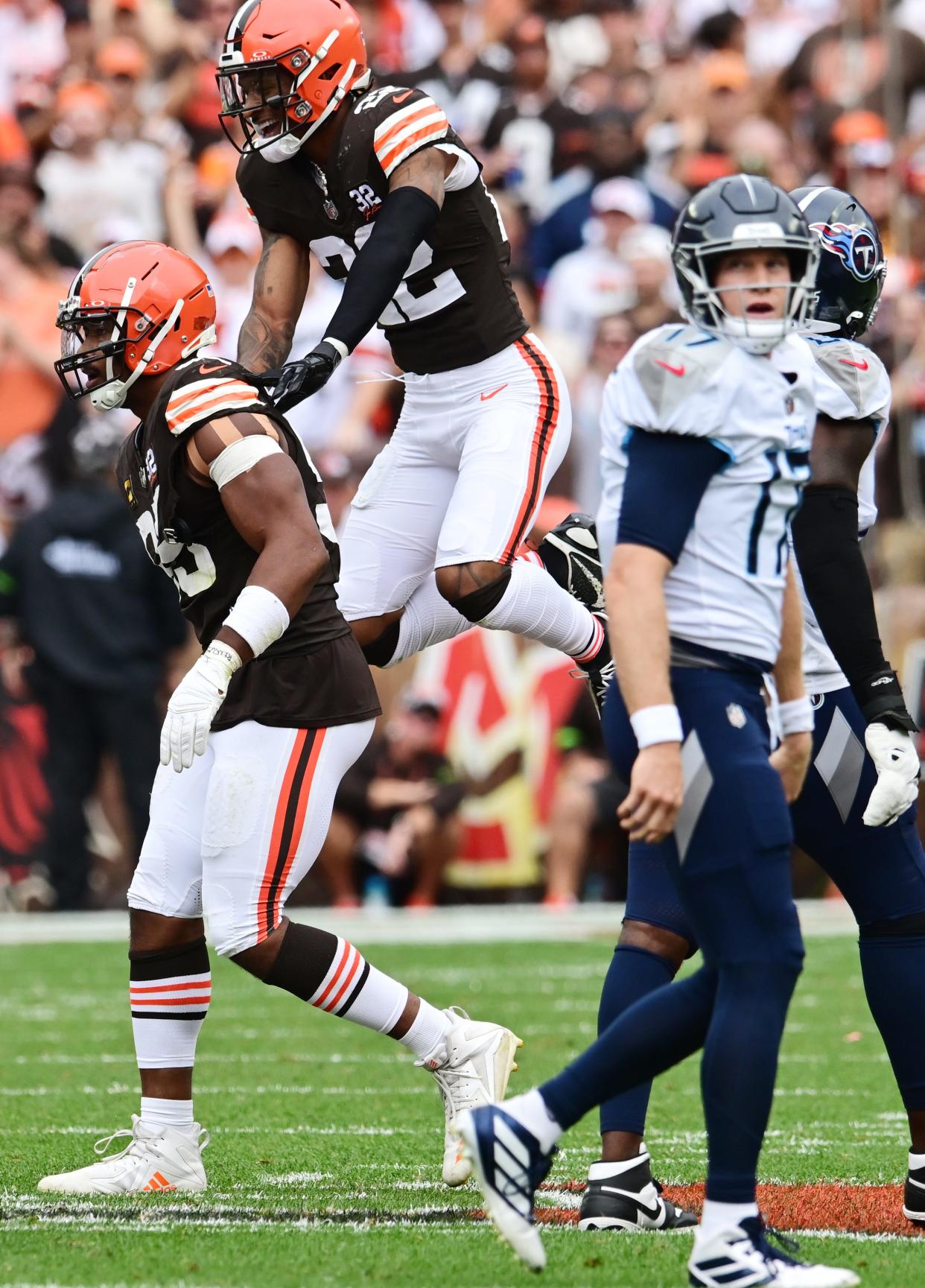 Cleveland Browns safety Grant Delpit (22) and defensive end Myles Garrett (95) celebrate as Tennessee Titans quarterback Ryan Tannehill (17) walks off the field Sept. 24 in Cleveland.