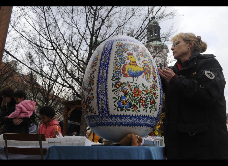 A female worker paints an Easter egg as tourists look at decorated Easter eggs on sales at the traditional Easter market in the Old Town Square in Prague. Easter eggs and other chocolate may be good for the heart and lower blood pressure, provide you eat a tiny amount each day and prefer dark rather than milk or white chocolate, a medical journal reported on Wednesday. Nutritionists in Germany monitored 19,357 adults aged between 35 and 65 for at least a decade, comparing episodes of ill health with their lifestyle.AFP PHOTO / MICHAL CIZEK 