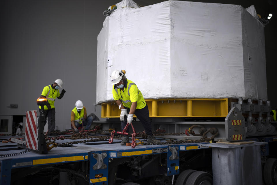 Workers receive a central solinoid magnet for the ITER project in Saint-Paul-Lez-Durance, France, Thursday, Sept. 9, 2021. Scientists at the International Thermonuclear Experimental Reactor in southern France took delivery of the first part of a massive magnet so strong its American manufacturer claims it can lift an aircraft carrier. (AP Photo/Daniel Cole)