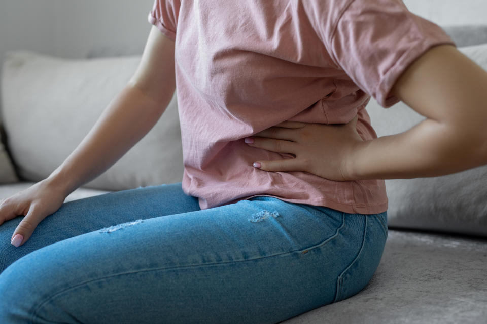 A person holding their left abdomen, likely due to liver, gallbladder or kidney pain. (Photo via Getty Images)