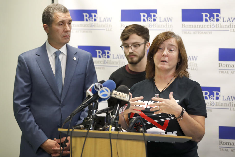 Polly Hergenreder, right, and her son Adam, center attend a news conference where their attorney Antonio Romanucci, announced the filing of a civil lawsuit against e-cigarette maker Juul on Hergenreder's behalf Friday, Sept. 13, 2019, in Chicago. The lawsuit filed Friday in Lake County, Illinois, Circuit Court alleges Juul Labs, Inc., deliberately targeted young people through Instagram and other sites to suggest vaping can boost their social status. It also says Juul doesn't fully disclose their products contain dangerous chemicals. (AP Photo/Charles Rex Arbogast)