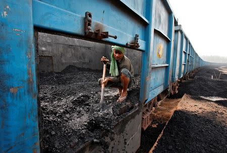 A worker unloads coal from a goods train at a railway yard in Chandigarh, July 8, 2014. REUTERS/Ajay Verma/Files