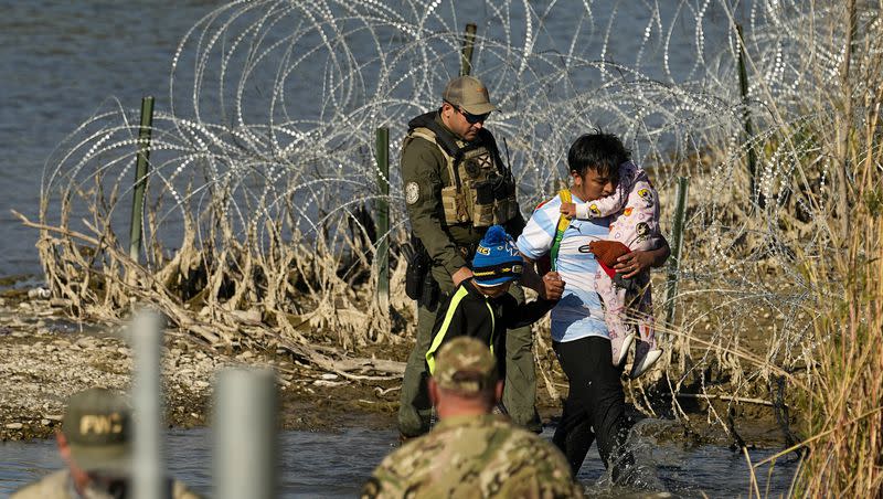 Migrants are taken into custody by officials at the Texas-Mexico border, Wednesday, Jan. 3, 2024, in Eagle Pass, Texas. 