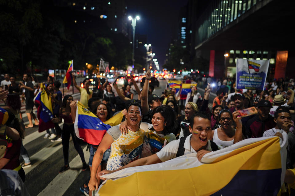 Venezuelan anti-government protesters hold their national flag as they block traffic during a demonstration in Sao Paulo, Brazil, Wednesday, Jan. 23, 2019. Venezuelan migrants held a rally against Venezuelan President Nicolas Maduro and in favor of Juan Guaido, head of Venezuela's opposition-run congress who today declared himself interim president of the South American nation. (AP Photo/Victor R. Caivano)