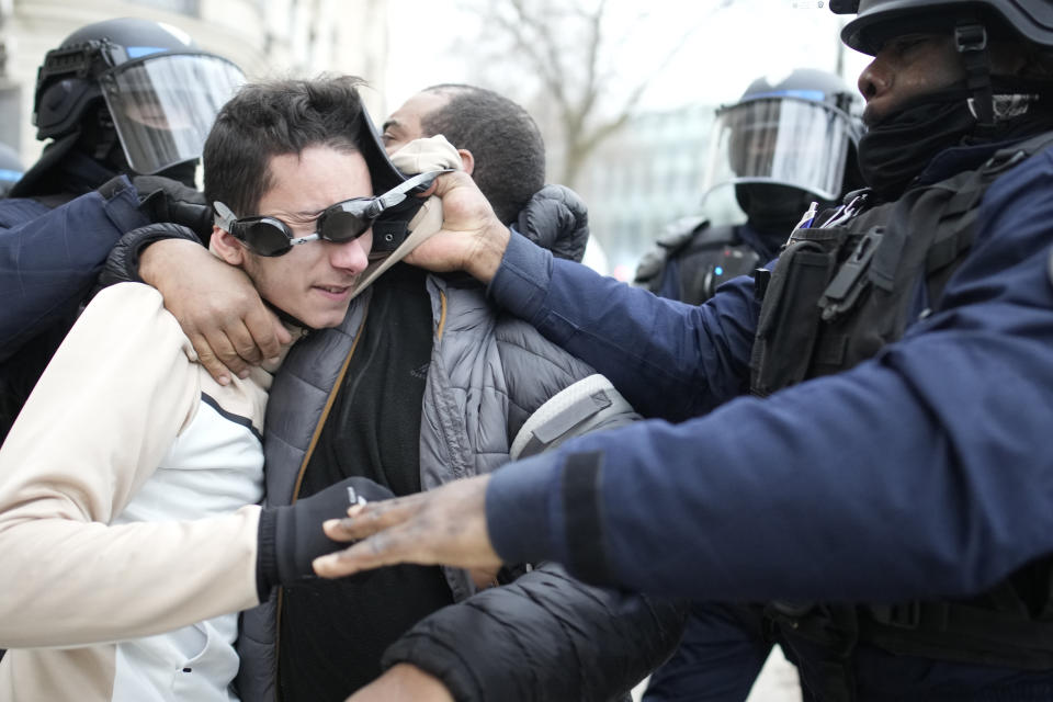 FILE - A man is detained by riot police officers during a demonstration against plans to push back France's retirement age, on Jan. 31, 2023 in Paris. French authorities see the police as protectors ensuring that citizens can peacefully protest President Emmanuel Macron’s contentious retirement age increase. But to human rights advocates and demonstrators who were clubbed or tear-gassed, officers have overstepped their mission. (AP Photo/Christophe Ena, File)