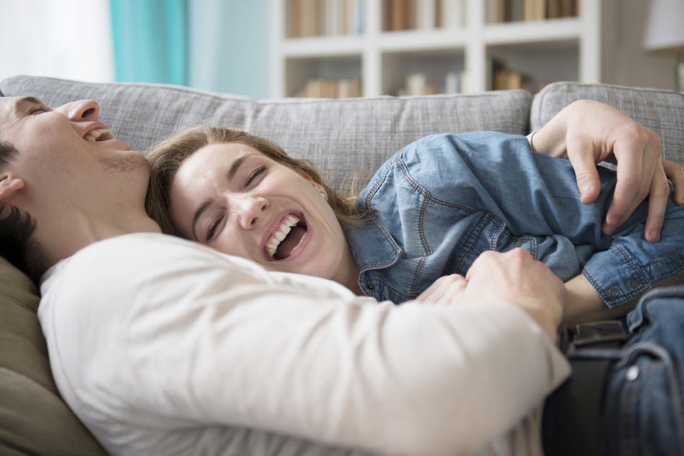 Couple laughing together on couch