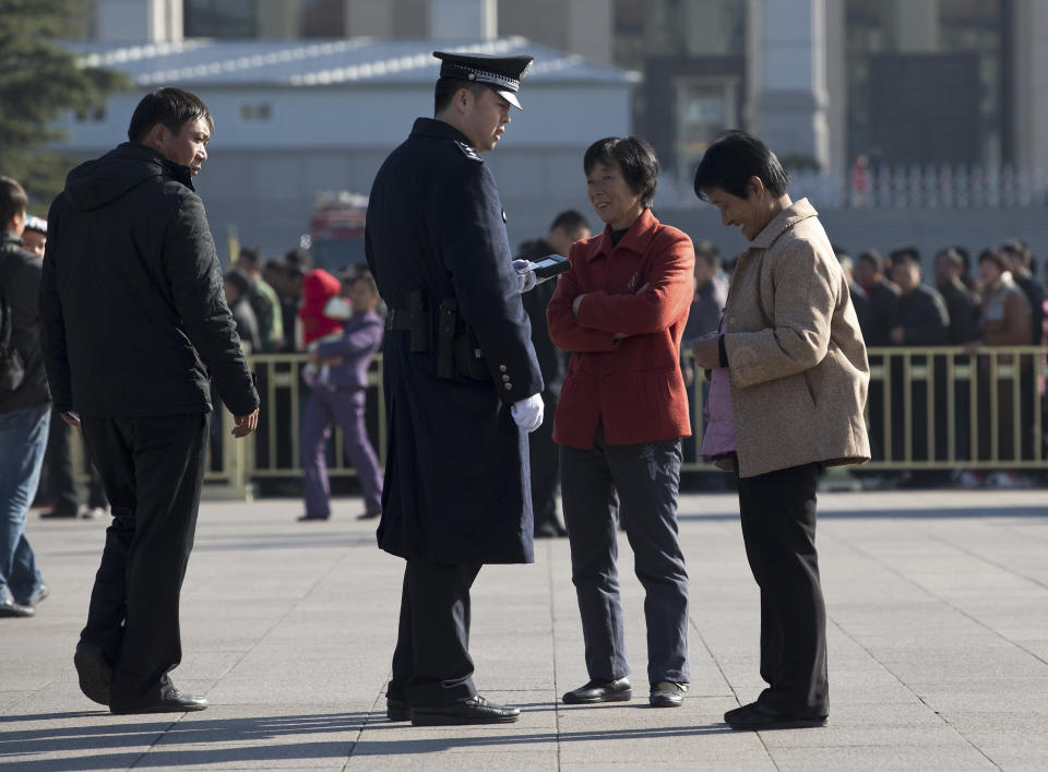 A policeman checks identities of women who visit Tiananmen Square in Beijing Thursday, Nov. 1, 2012 as the all-important Party Congress approaches. Beijing usually tightens security for high-profile political events, and this one is the most pivotal for the Communist Party in 10 years. But sometimes the measures can pass into the downright bizarre. (AP Photo/Andy Wong)