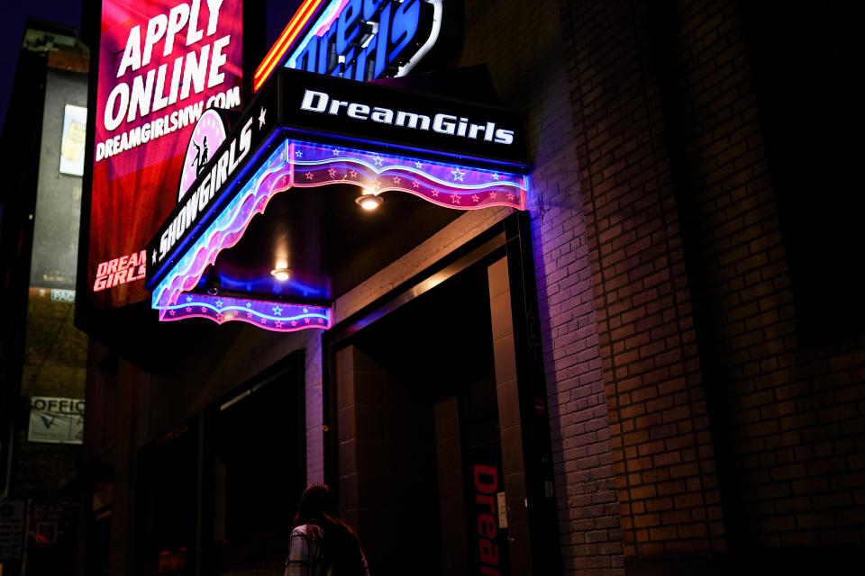 A person walks by the Dream Girls at SoDo strip club, Monday, Feb. 5, 2024, in Seattle. Adult dancers are fighting for bills to pass in the state Legislature that would expand statewide protections to workers, like having a security guard at each club, keypad codes to enter dressing rooms and deescalation training. (AP Photo/Lindsey Wasson)