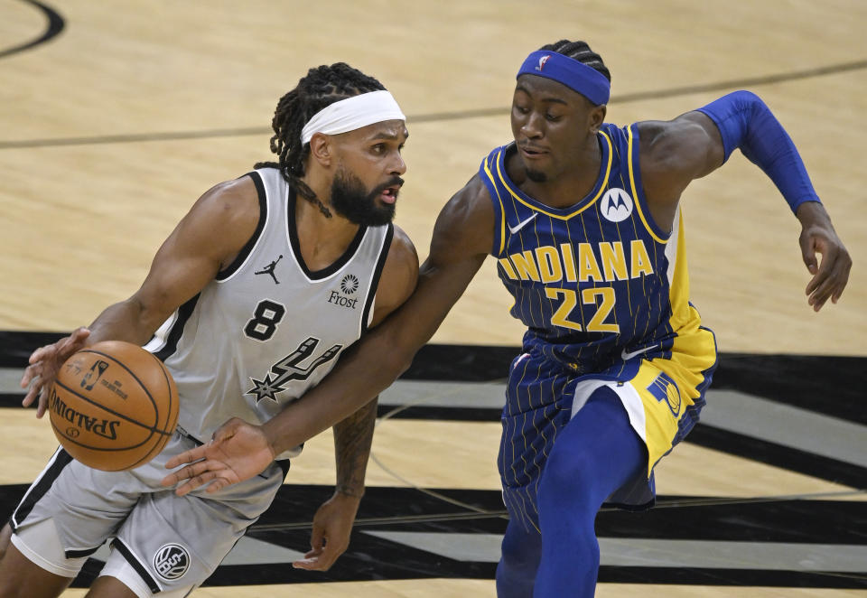 San Antonio Spurs' Patty Mills (8) drives against Indiana Pacers' Caris LeVert during the first half of an NBA basketball game Saturday, April 3, 2021, in San Antonio. (AP Photo/Darren Abate)