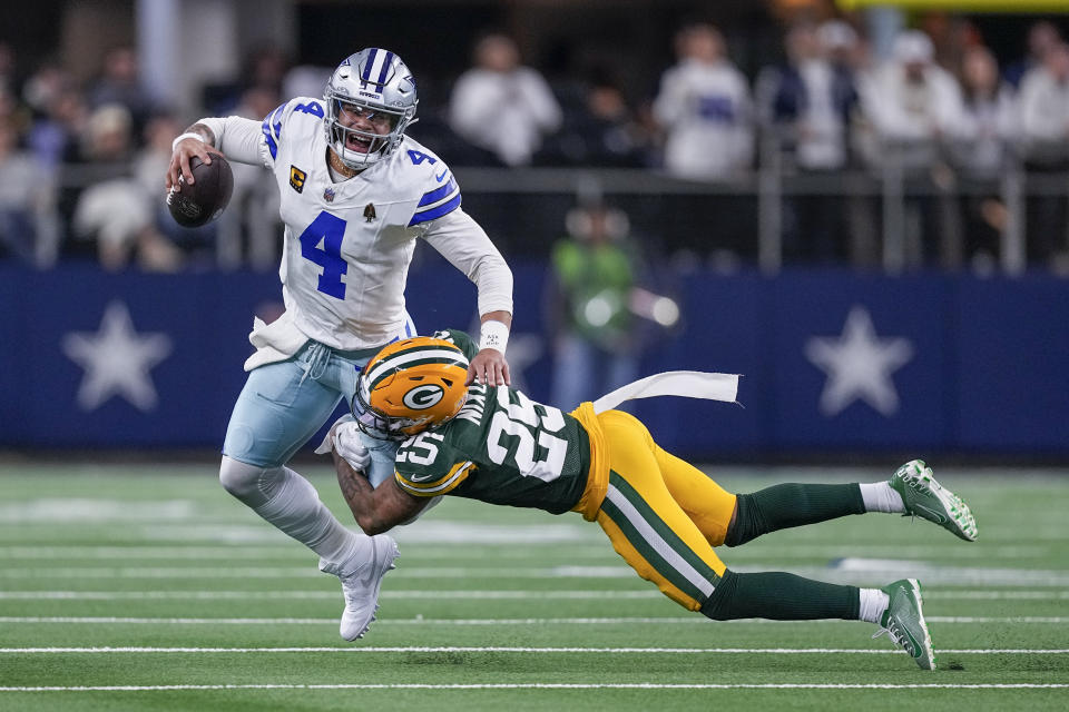 Dallas Cowboys quarterback Dak Prescott (4) is brought down by Green Bay Packers cornerback Keisean Nixon (25) during the first half of an NFL football game, Sunday, Jan. 14, 2024, in Arlington, Texas. (AP Photo/Sam Hodde)