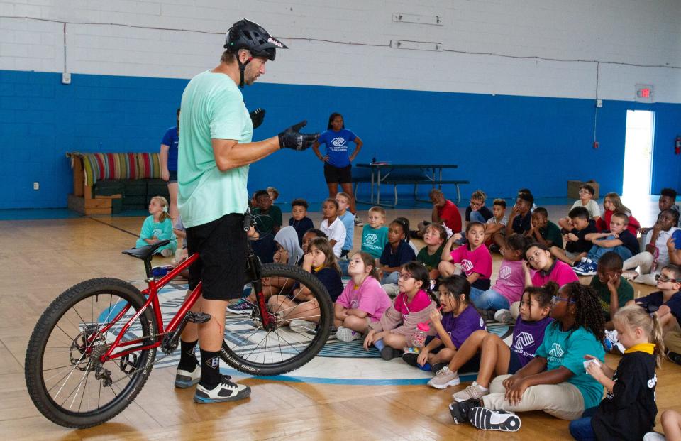 Professional mountain biker Jeff Lenosky offers some lessons Wednesday afternoon for children in an after-school program at the Boys and Girls Clubs of Polk County's James J. Musso Unit. Lenosky performed a set of tricks before children in the program received free bicycles.