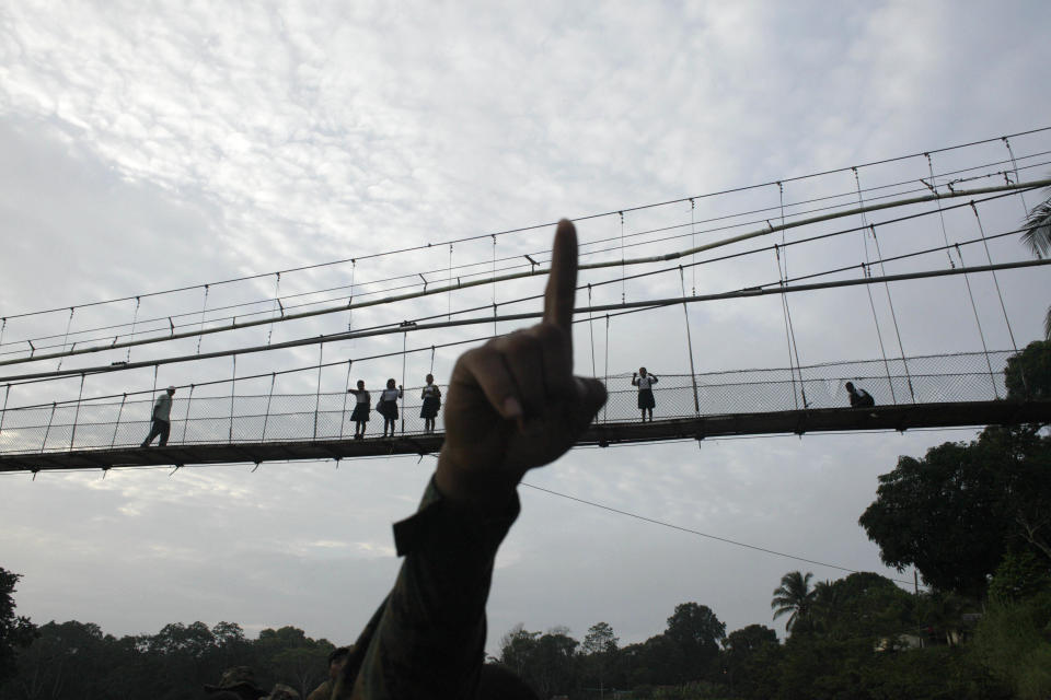 FILE - In this June 19, 2012, file photo, a Panama border police officer points as he begins to patrol in the Darien Province, on the border with Colombia, in Yaviza, Panama. The area is known as the Darien Gap, a 60-mile (97-kilometer) stretch of roadless jungle straddling the border of Colombia and Panama. One man's journey to America from his home in Mauritania was a dangerous and arduous one that took him through the Darien Gap. (AP Photo/Arnulfo Franco, File)