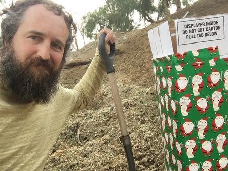 Robert Strong is seen next to a gift-wrapped box in this photo released by Robert Strong of Eagle Rock, California, U.S. released on December 25, 2017. Courtesy Robert Strong/Handout via REUTERS