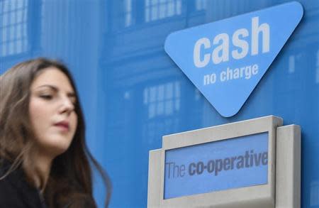 A woman walks past a branch of the Co-operative Bank in central London May 10, 2013. REUTERS/Toby Melville