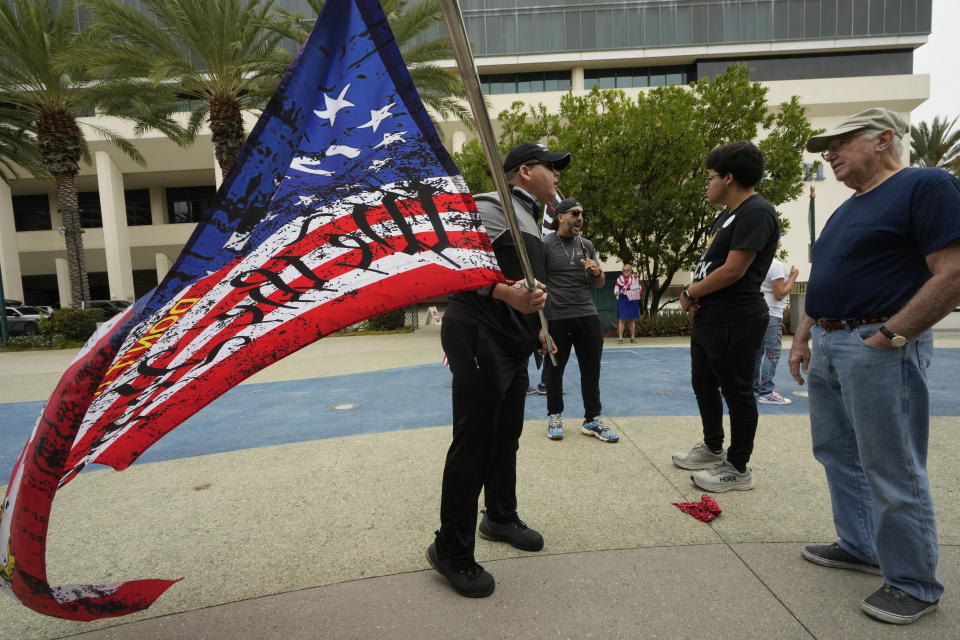 Former President Donald Trump supporters, left, engage with members of the Democratic Party of Orange County holding a rally where the 2023 Fall California Republican Convention is being held in Anaheim, Calif., Friday, Sept. 29, 2023. (AP Photo/Damian Dovarganes)